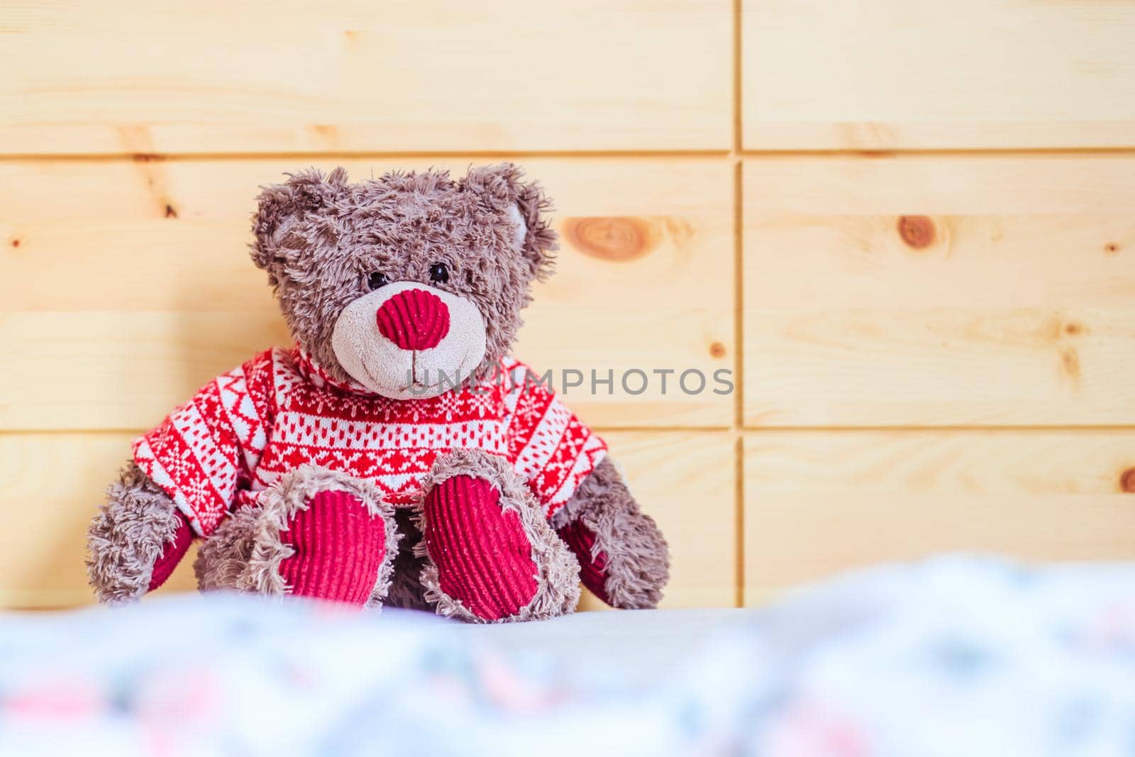 Cute teddy bear toy is sitting in the bed, wakeup at morning
