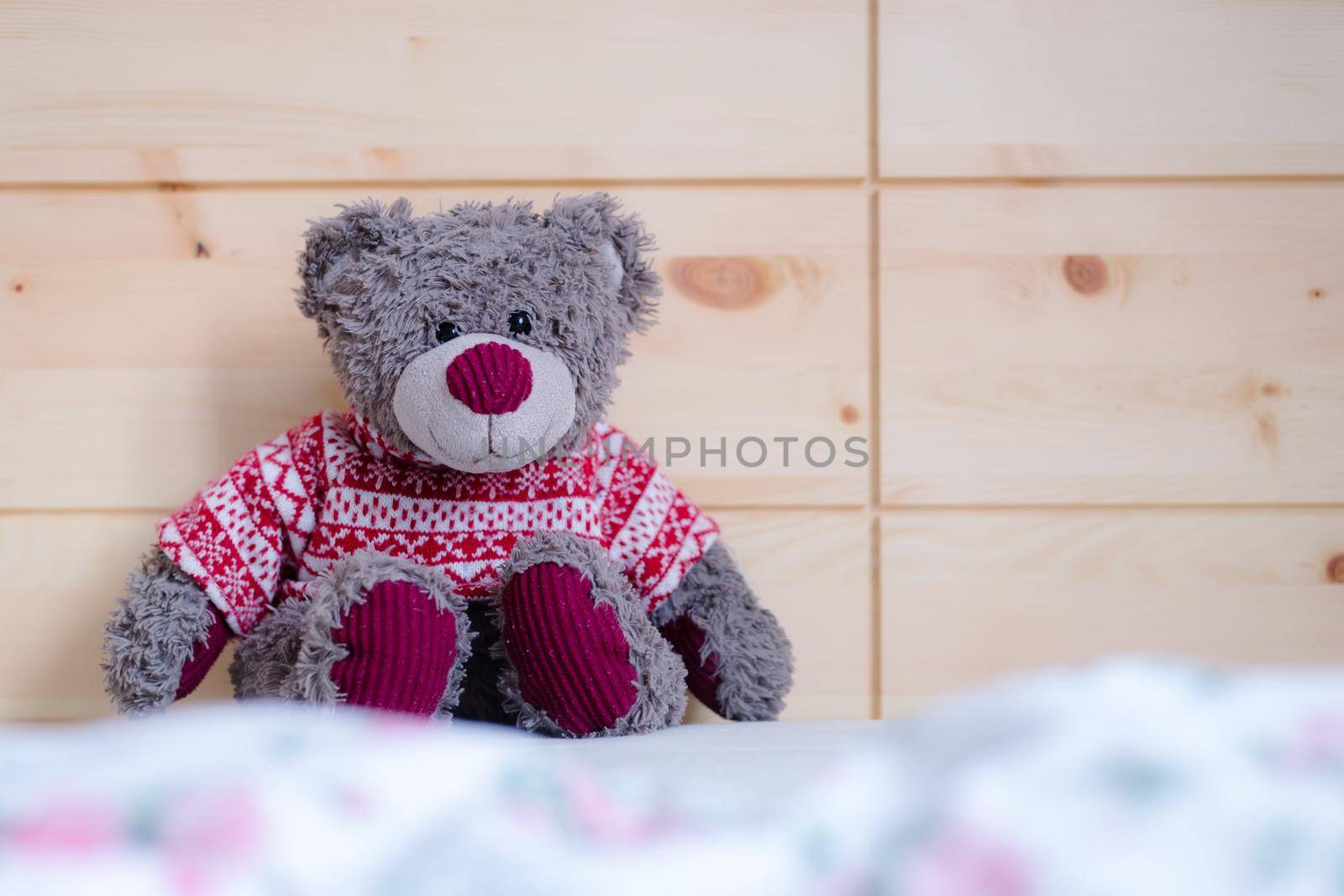 Cute teddy bear toy is sitting in the bed, wakeup at morning