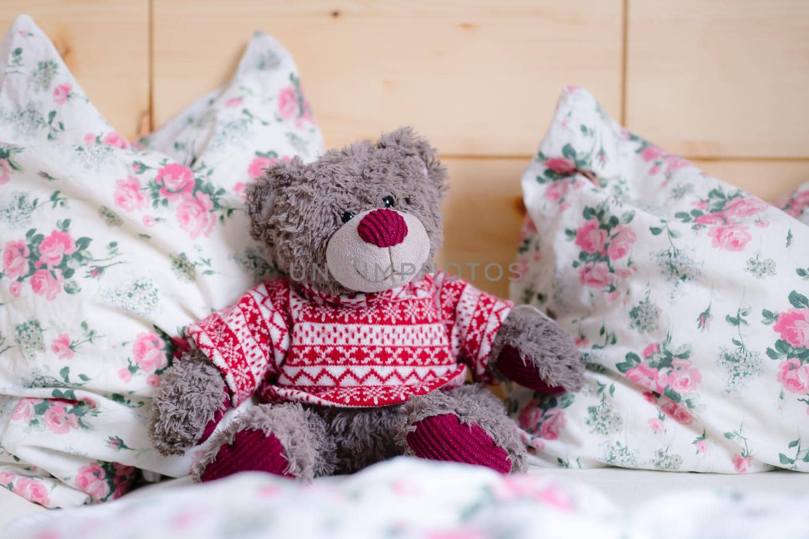 Teddy dream concept: Teddy bear is sitting in a wooden bed by Daxenbichler