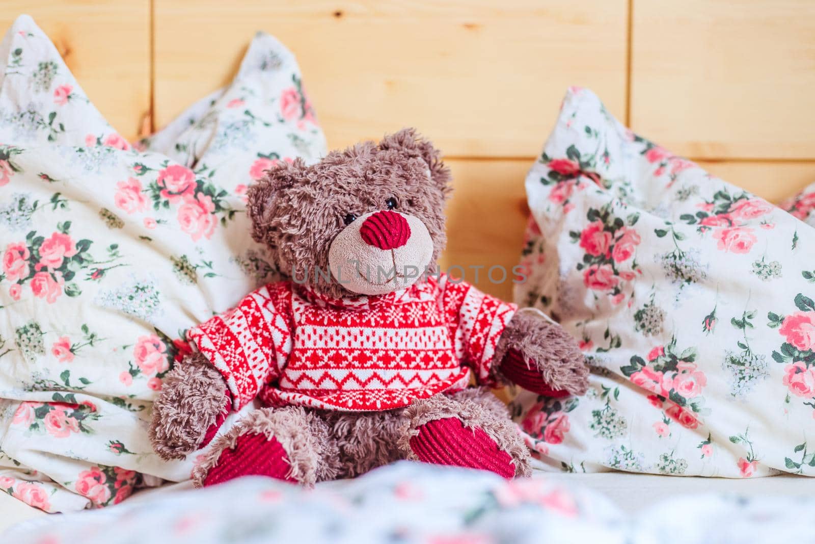 Cute teddy bear toy is sitting in the bed, wakeup at morning