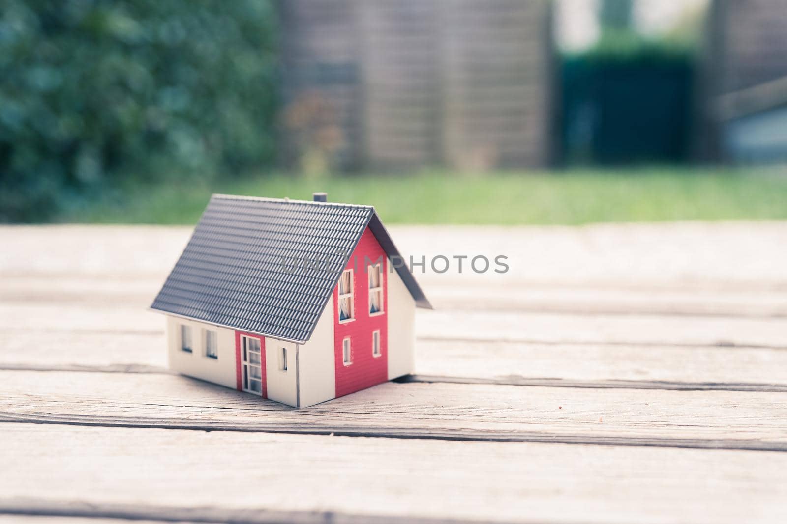 Red house model on the floor, outdoors. Concept for new home, property and estate
