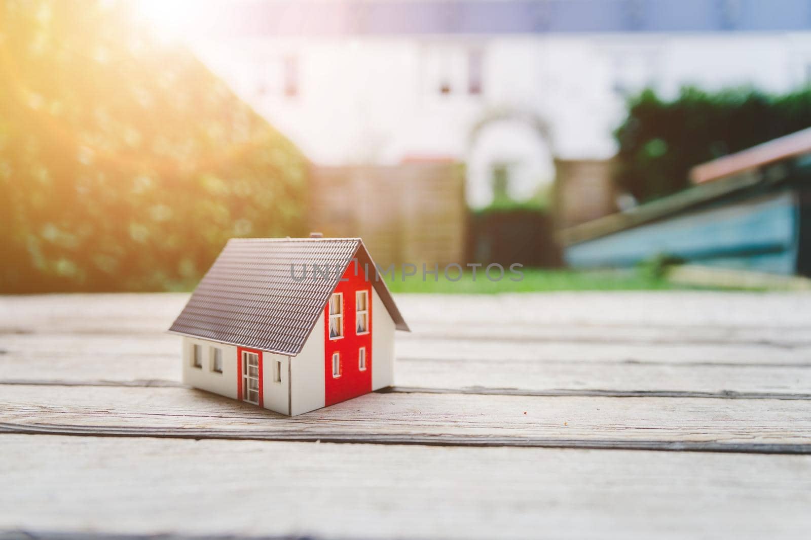 Red house model on the floor, outdoors. Concept for new home, property and estate