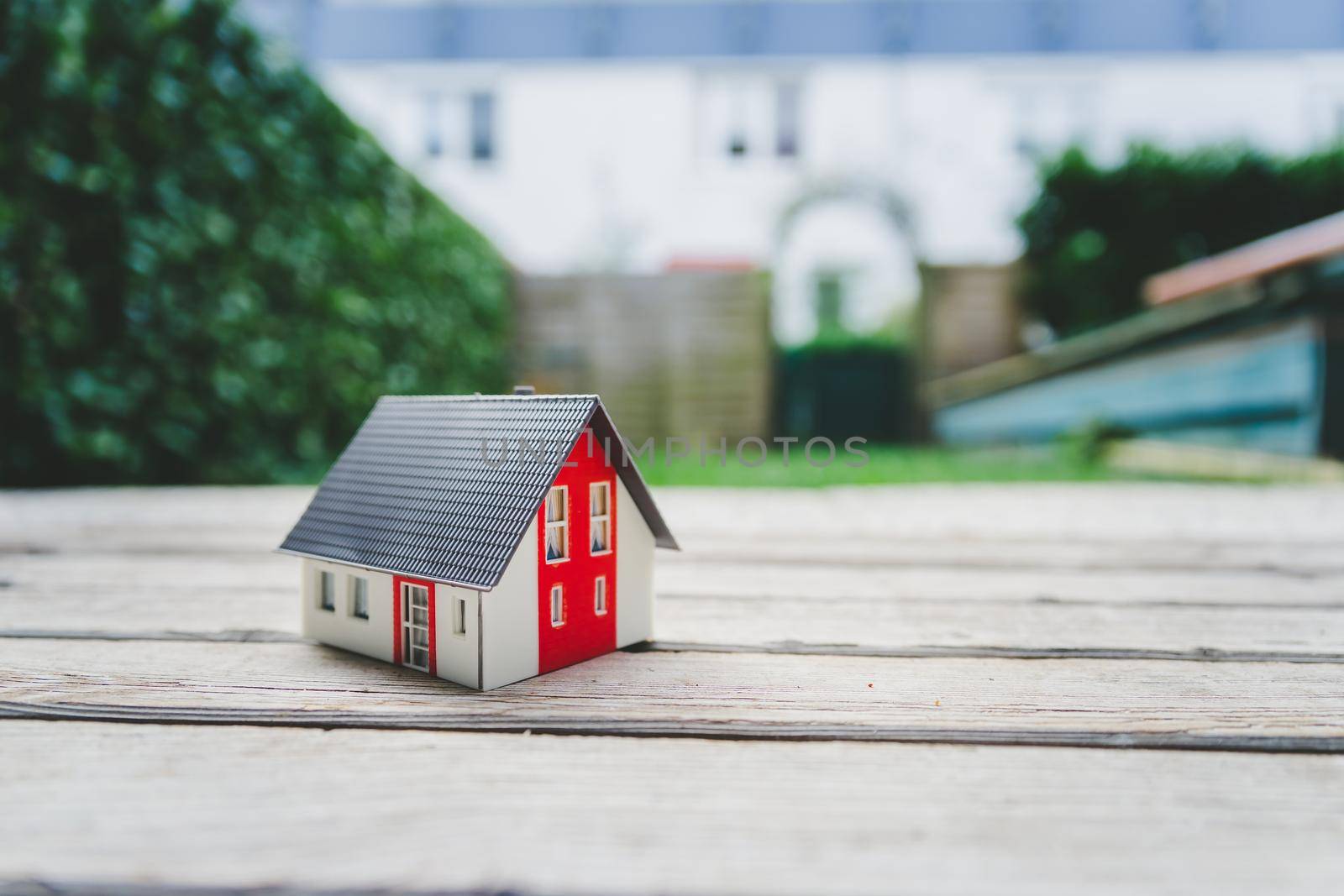 Red house model on the floor, outdoors. Concept for new home, property and estate