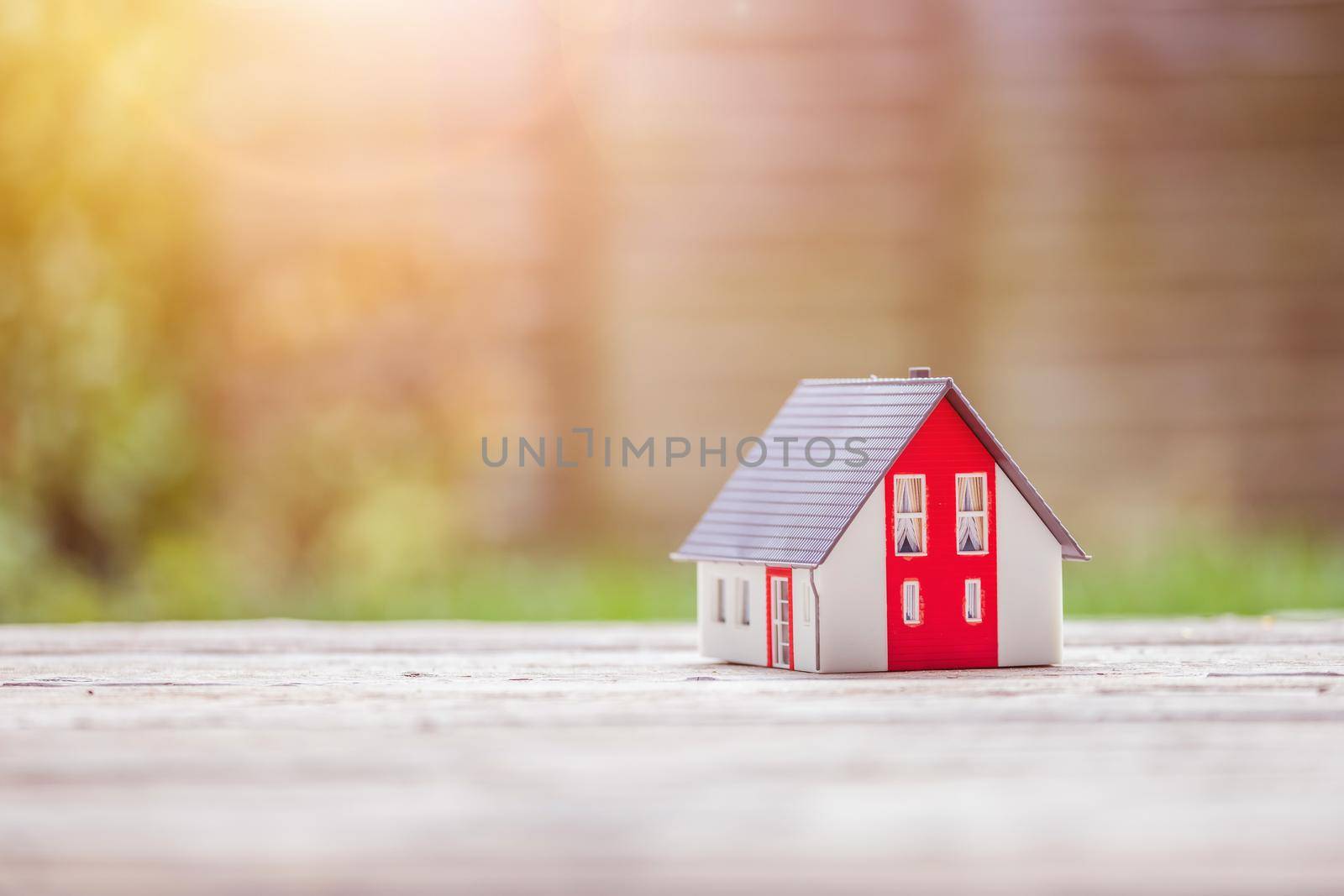 Red house model on the floor, outdoors. Concept for new home, property and estate, copy space