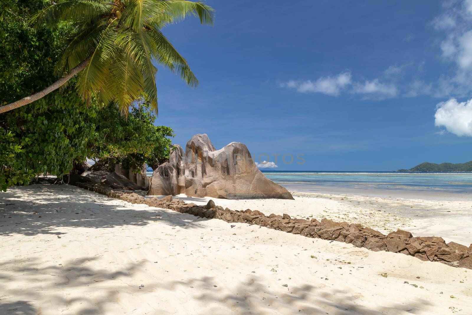 Beautiful beach Anse Source D'Argent on Seychelles island La Digue with white sand, blue water, granite rocks on the beach and blue sky with white clouds