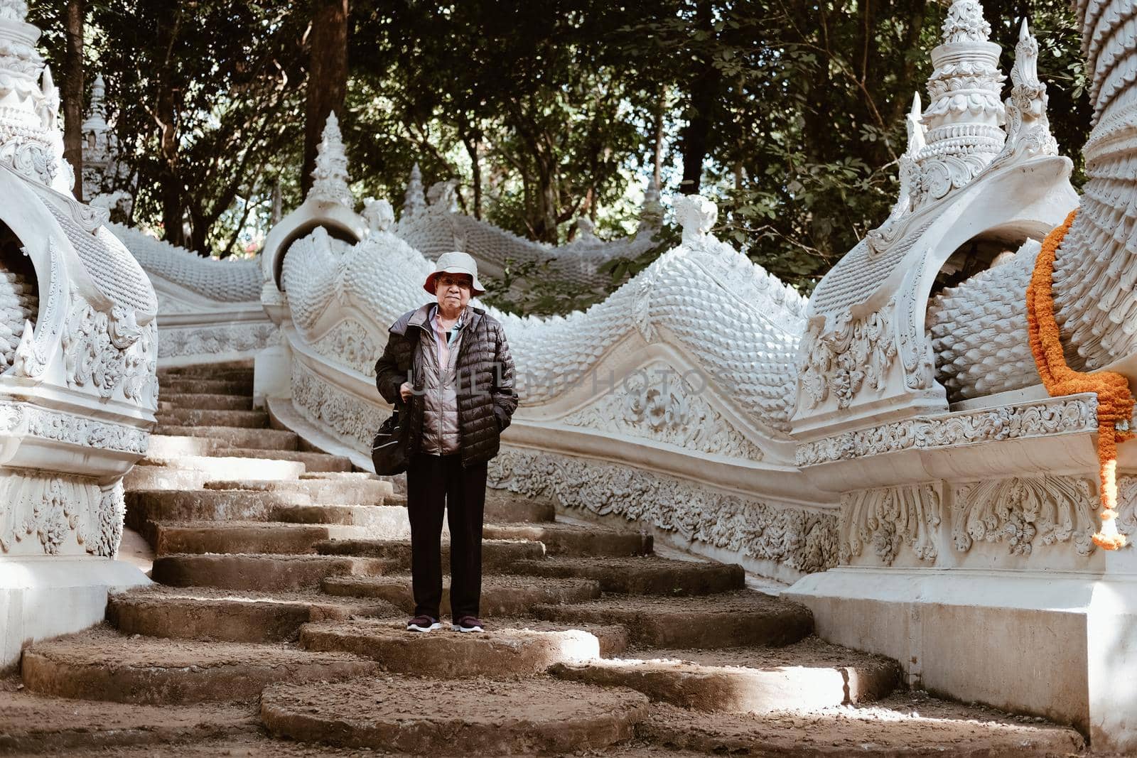 old elderly female elder woman traveller traveling in asian temple. senior leisure lifestyle