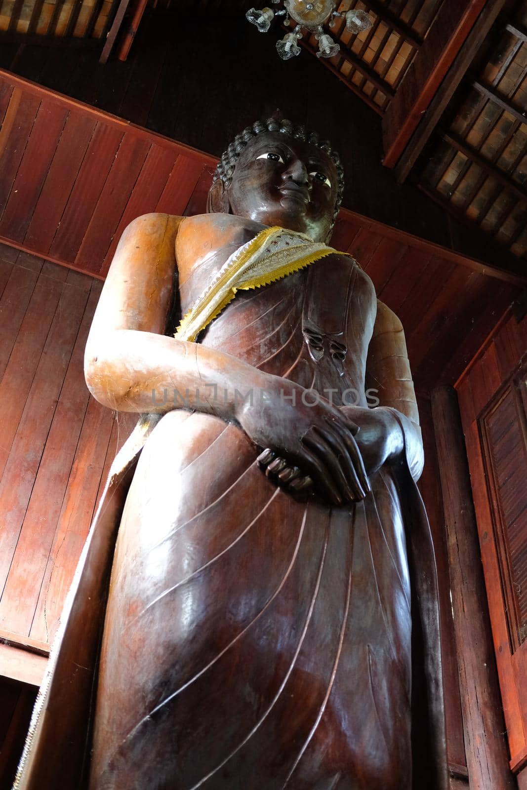 standing buddha statue stupa in asian wooden buddhist temple in Thailand