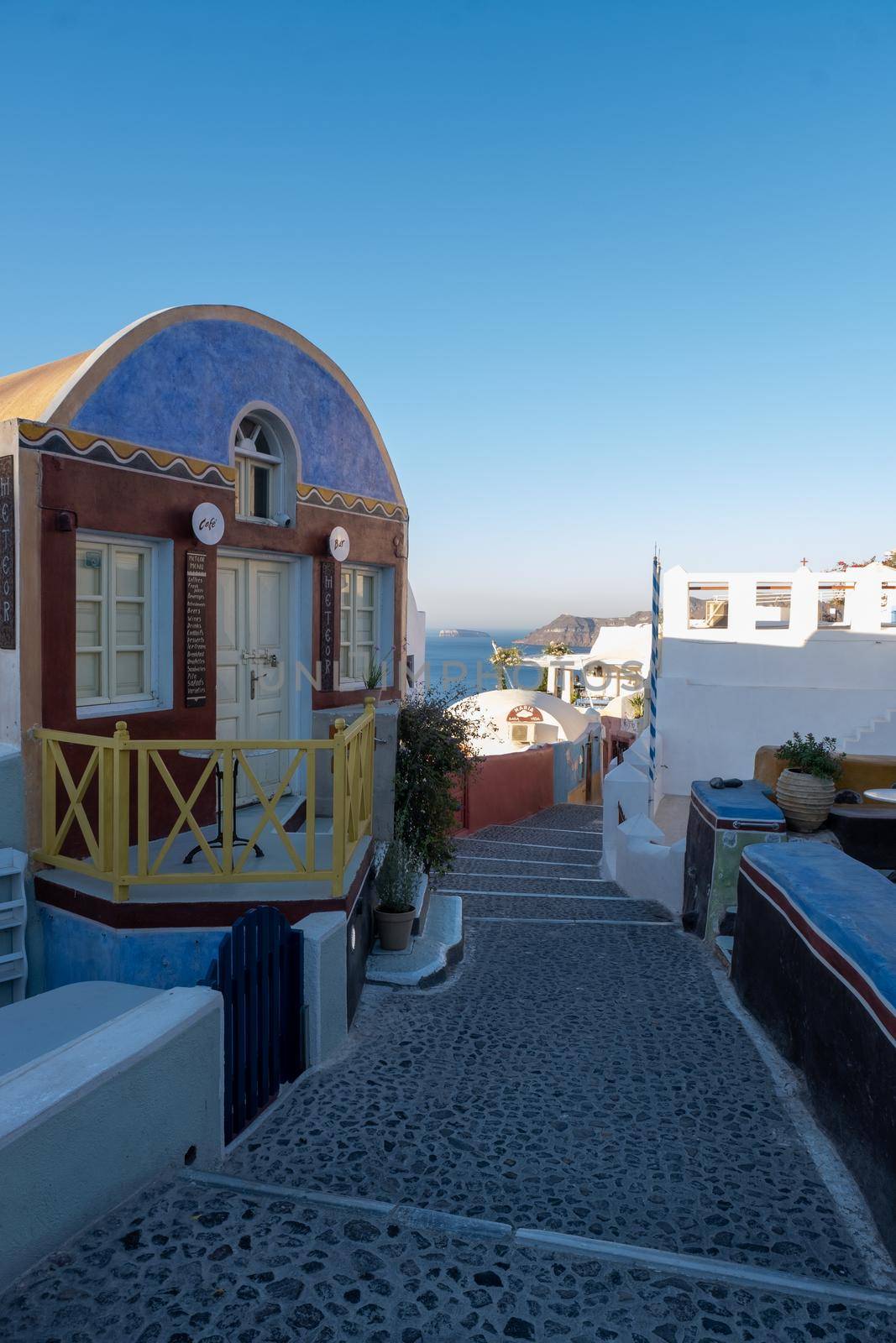 Santorini Greece August 2020, streets of Oia on a early morning with cafe and restaurant by fokkebok