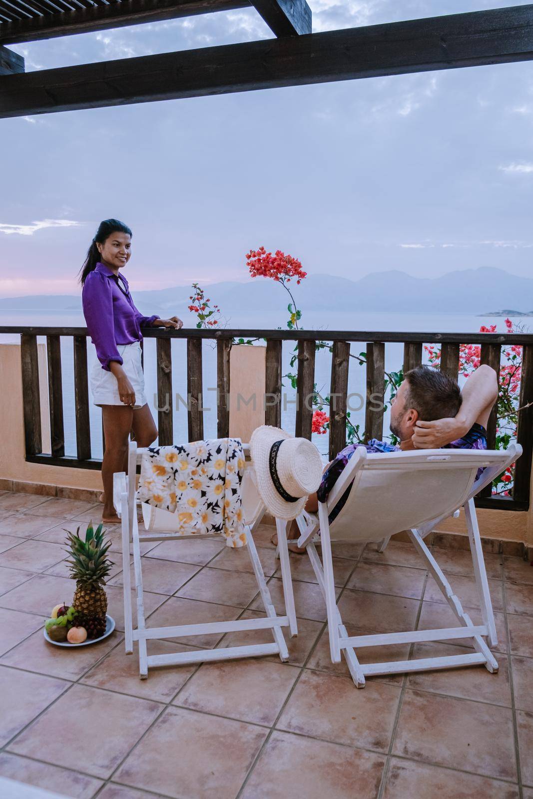 table and chairs with breakfast during sunrise at the meditarian sea in Greece. Couple having breakfast on balcony looking out over the ocean