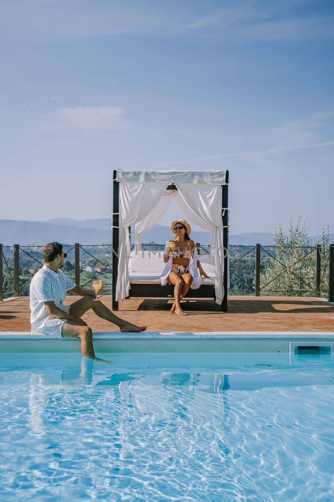 Luxury country house with swimming pool in Italy. Pool and old farm house during sunset central Italy. Couple on Vacation at luxury villa in Italy, men and woman watching sunset