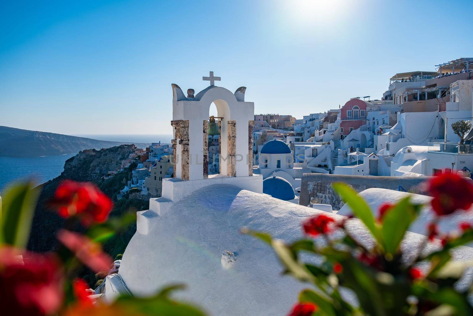 Sunset at the Island Of Santorini Greece, beautiful whitewashed village Oia with church and windmill during sunset by fokkebok