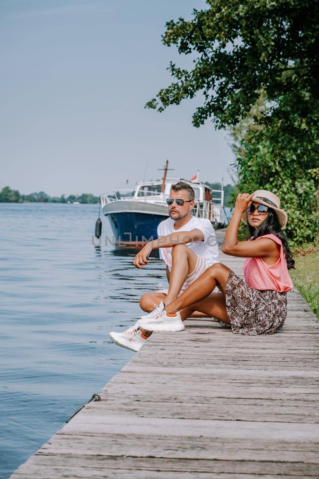 people relaxing in the park by the lake in the Netherlands Vinkeveen near Amsterdam, Vinkeveen is mainly famous for the Vinkeveense Plassen Lakes of Vinkeveen, an area of lakes and sand islands east of the village by fokkebok