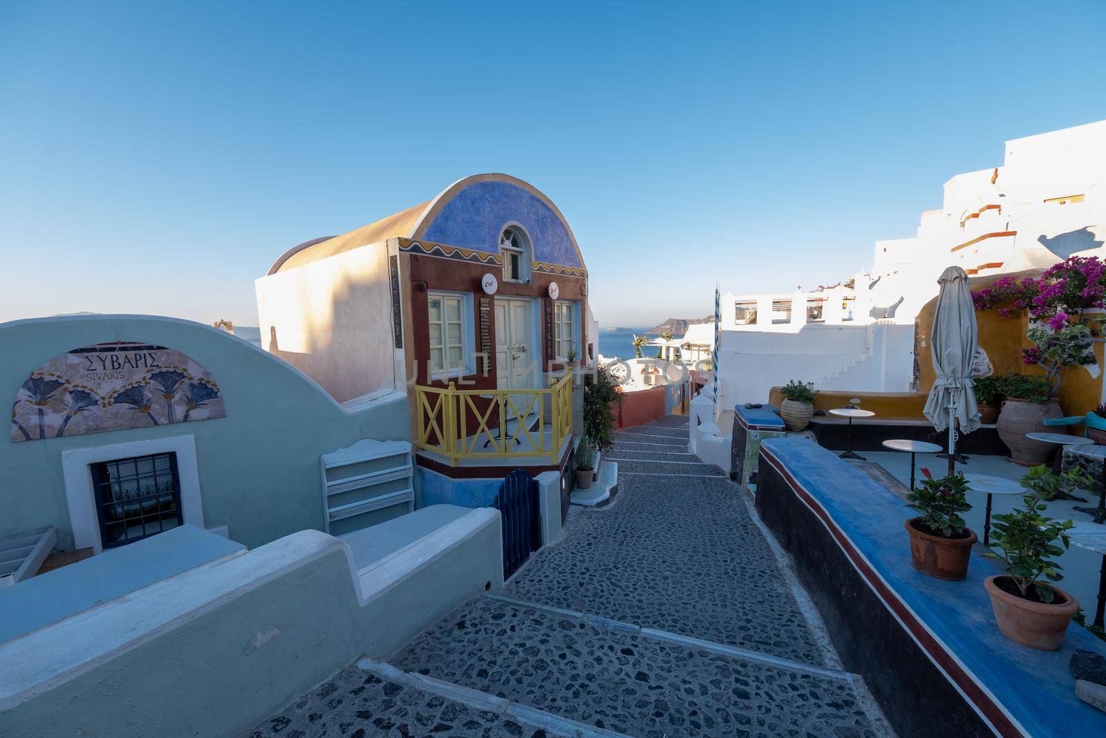 Santorini Greece August 2020, streets of Oia on a early morning with cafe and restaurant by fokkebok