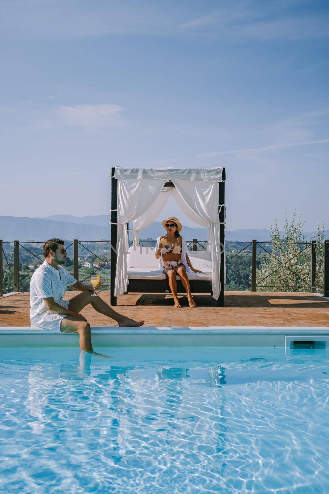 Luxury country house with swimming pool in Italy. Pool and old farm house during sunset central Italy. Couple on Vacation at luxury villa in Italy, men and woman watching sunset