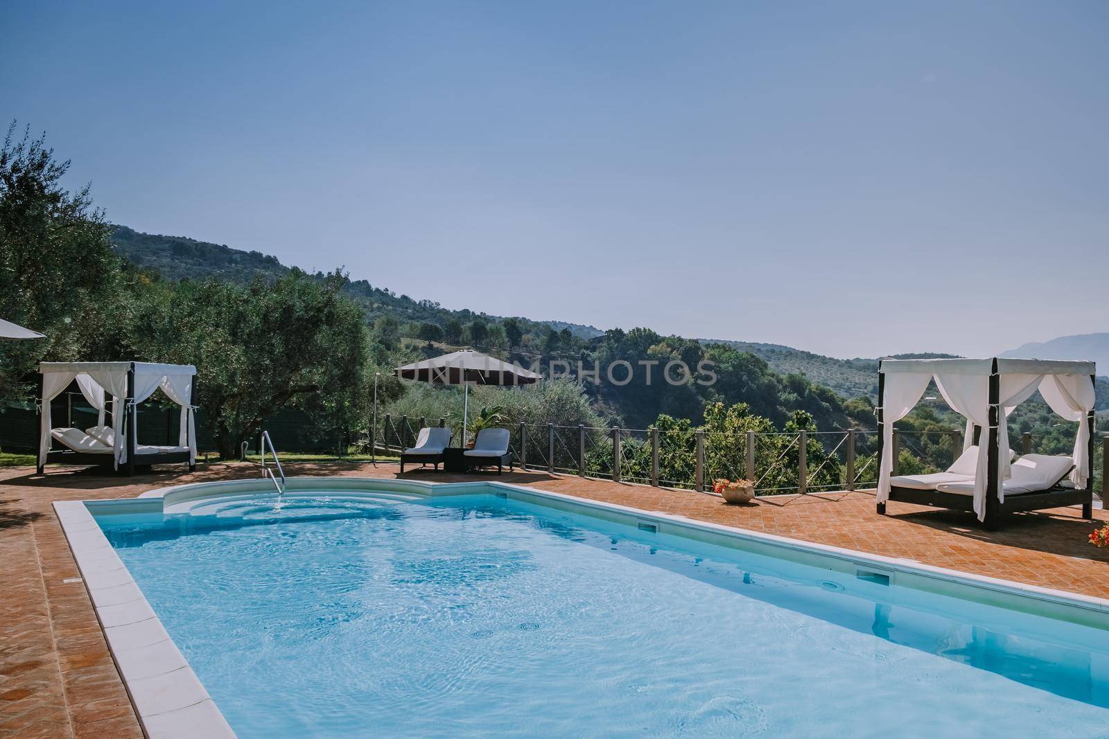 Luxury country house with swimming pool in Italy. Pool and old farm house during sunset central Italy. Couple on Vacation at luxury villa in Italy, men and woman watching sunset