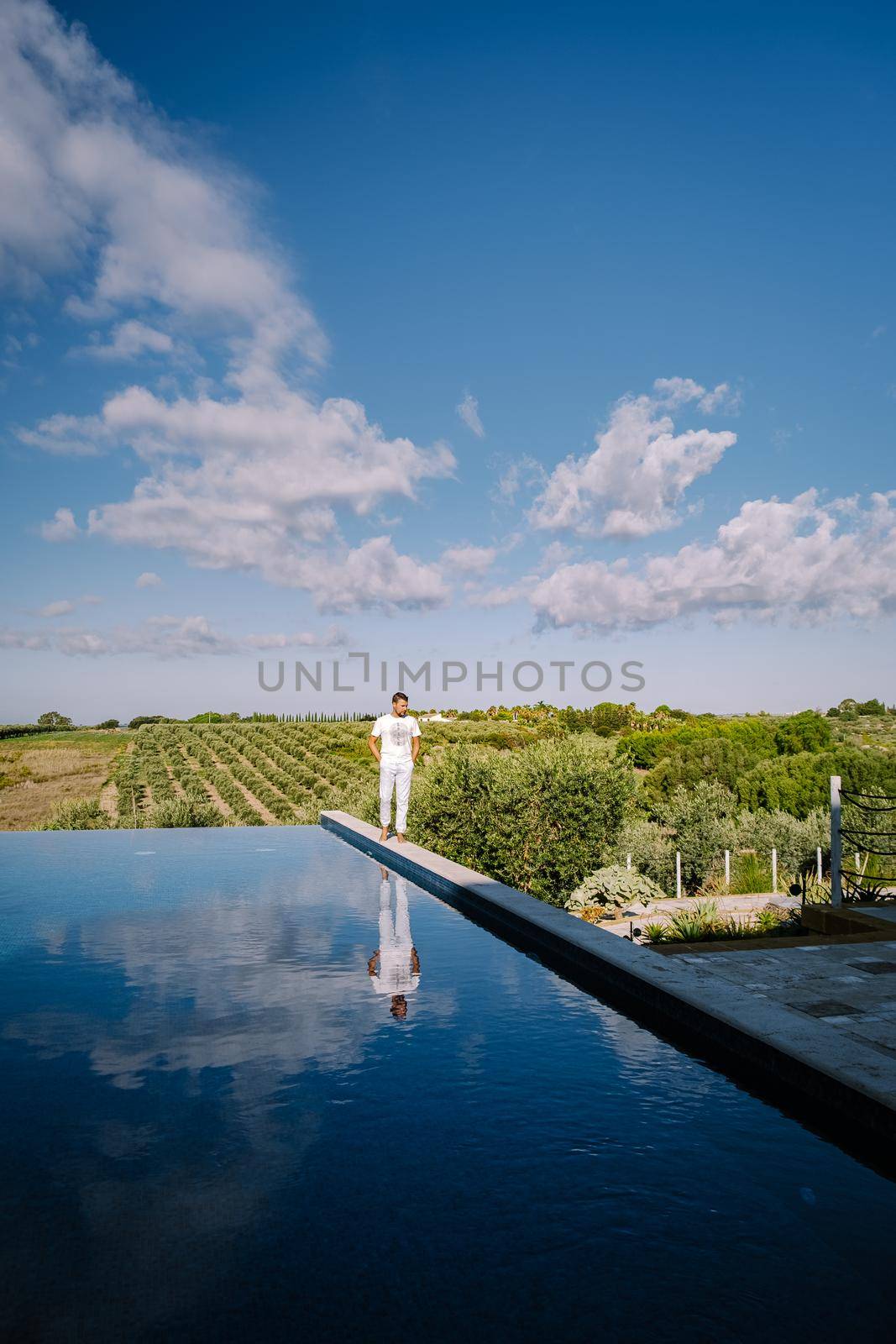 Luxury resort with a view over the wine field in Selinunte Sicily Italy. infinity pool with a view over wine fields in Sicilia men on vacation luxury hotel
