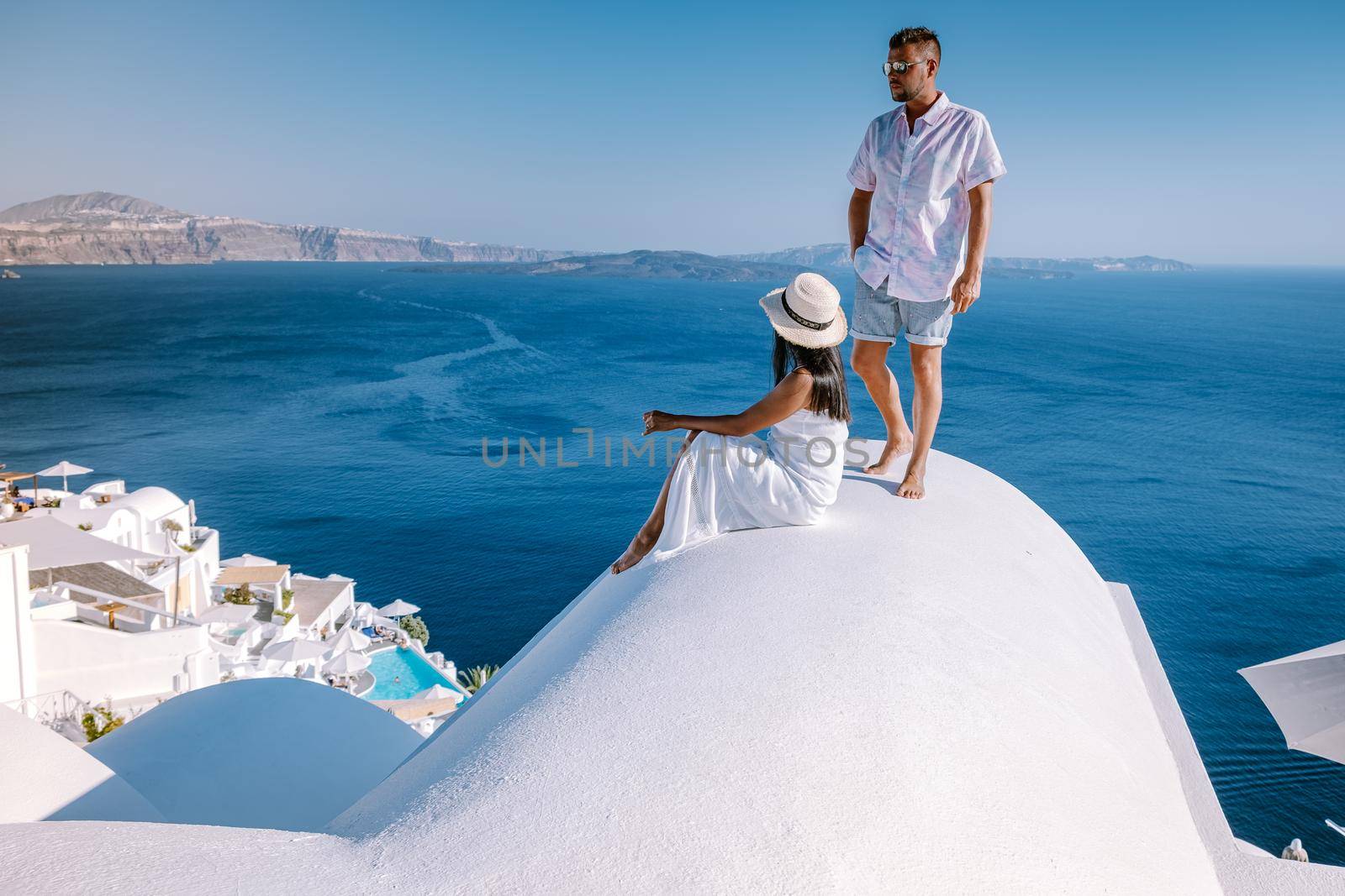 couple men and woman on vacation Santorini, View to the sea and Volcano from Fira the capital of Santorini island in Greece by fokkebok