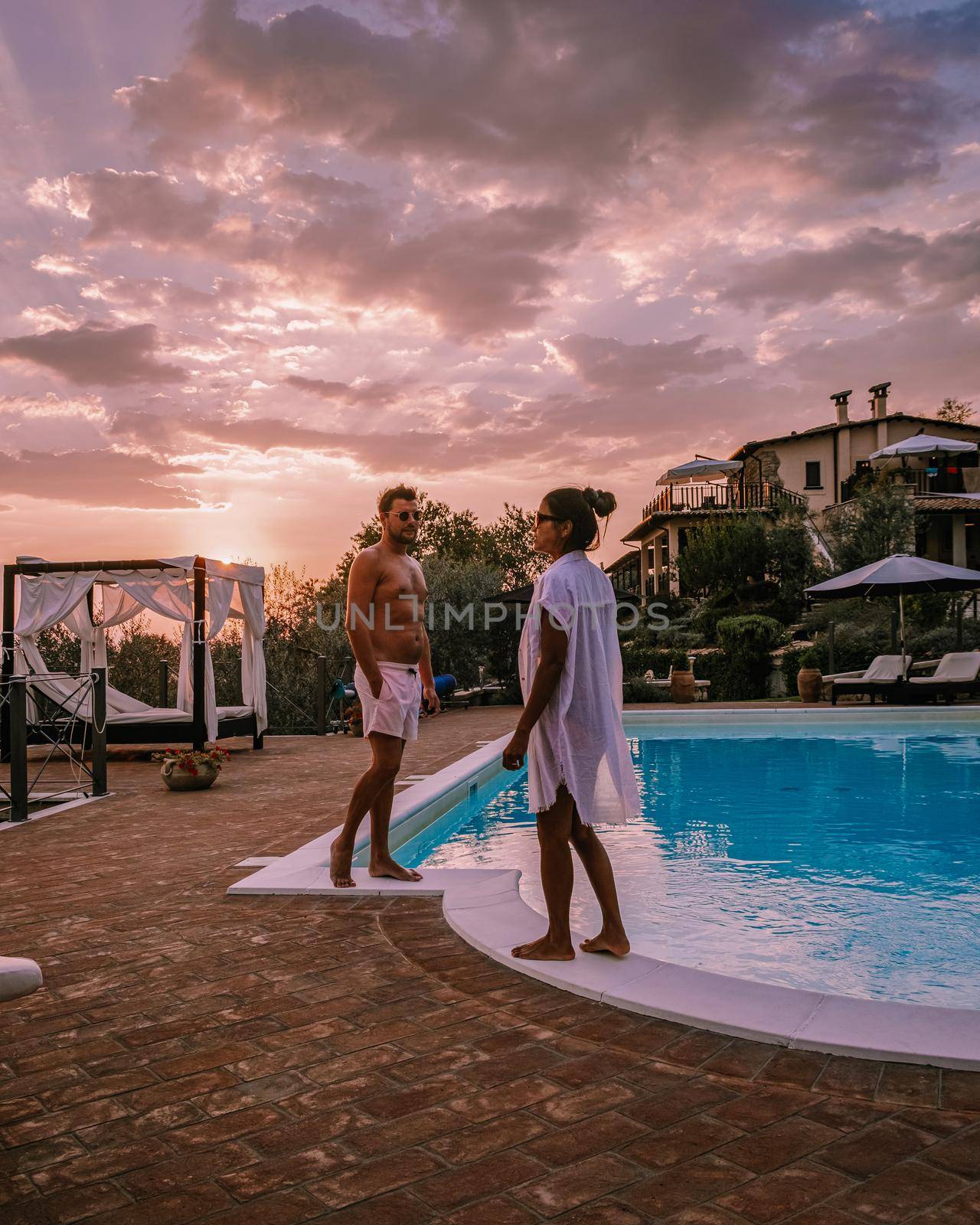 Luxury country house with swimming pool in Italy, Couple on Vacation at luxury villa in Italy, men and woman watching sunset by fokkebok