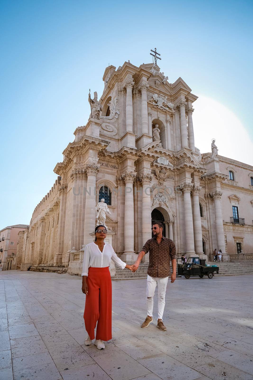 couple men and woman on citytrip Ortigia in Syracuse in the Morning. Travel Photography from Syracuse, Italy on the island of Sicily. Cathedral Plaza and market with people whear face protection during the 2020 pandemic by fokkebok