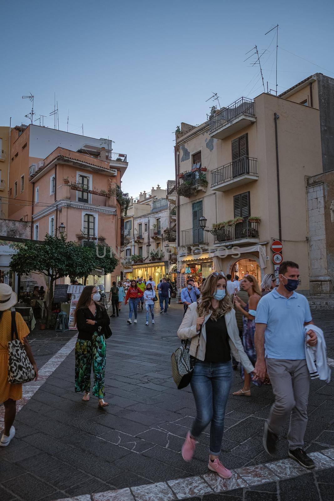 Taormina Sicily , people on the streets using fase mask during the pandemic Corona Covid 19 virus outbreak by fokkebok