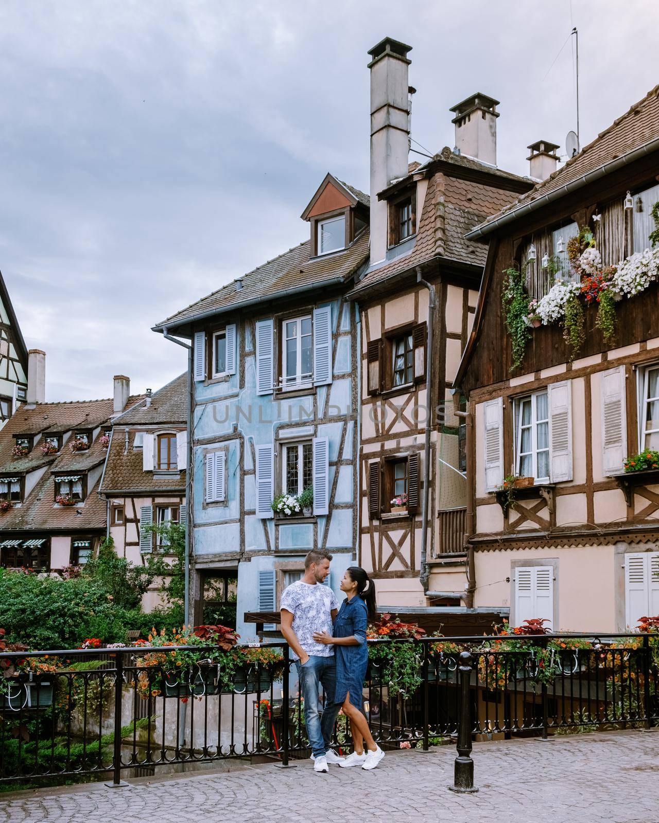 couple on city trip Colmar, Alsace, France. Petite Venice, water canal and traditional half timbered houses. Colmar is a charming town in Alsace, France. Beautiful view of colorful romantic city Colmar, France, Alsace by fokkebok