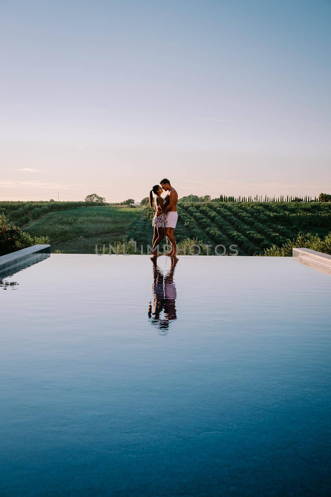 Luxury resort with a view over the wine field in Selinunte Sicily Italy. infinity pool with a view over wine fields in Sicilia, a couple on luxury vacation at the Island of Sicily Italy