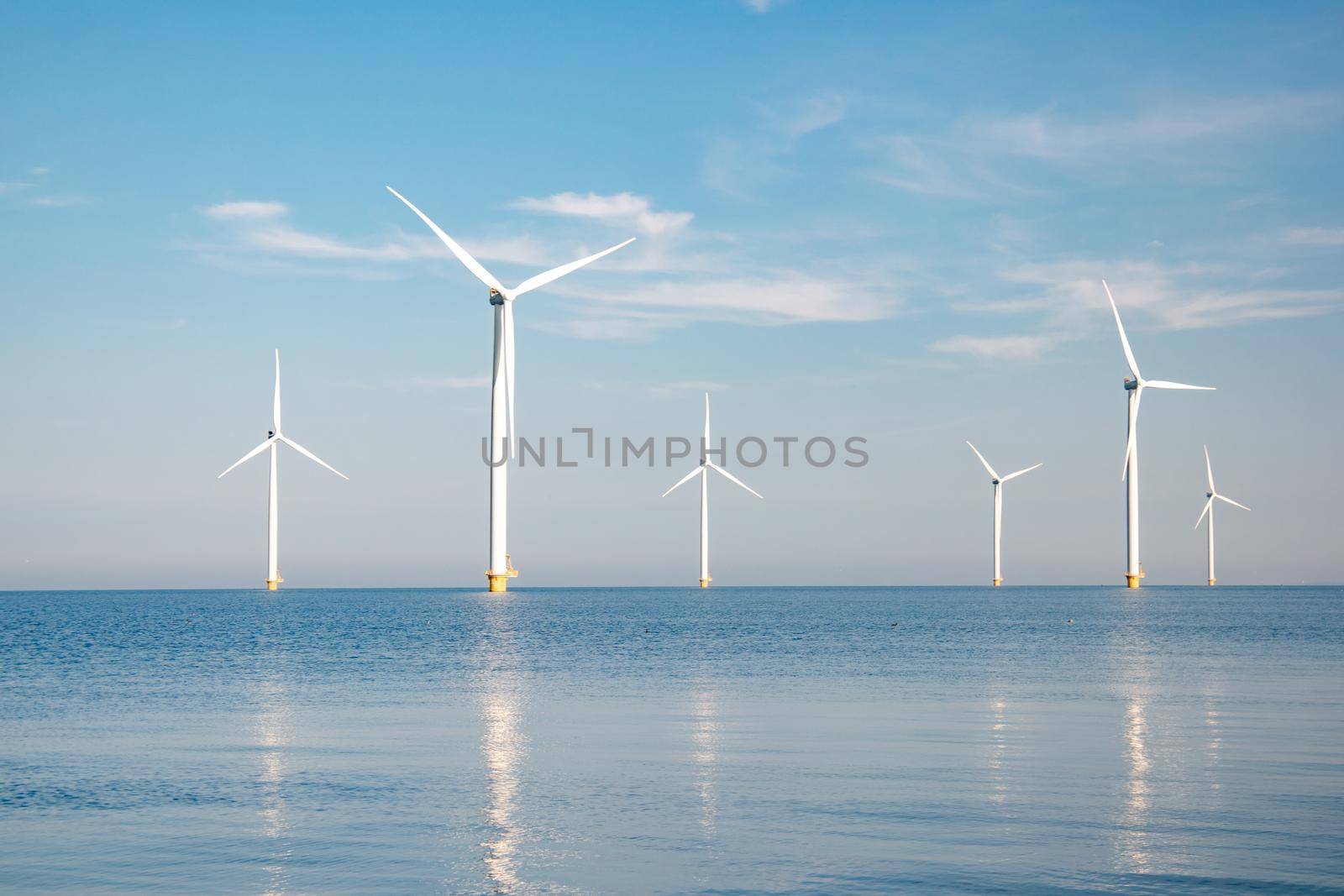 offshore windmill park with stormy clouds and a blue sky, windmill park in the ocean by fokkebok