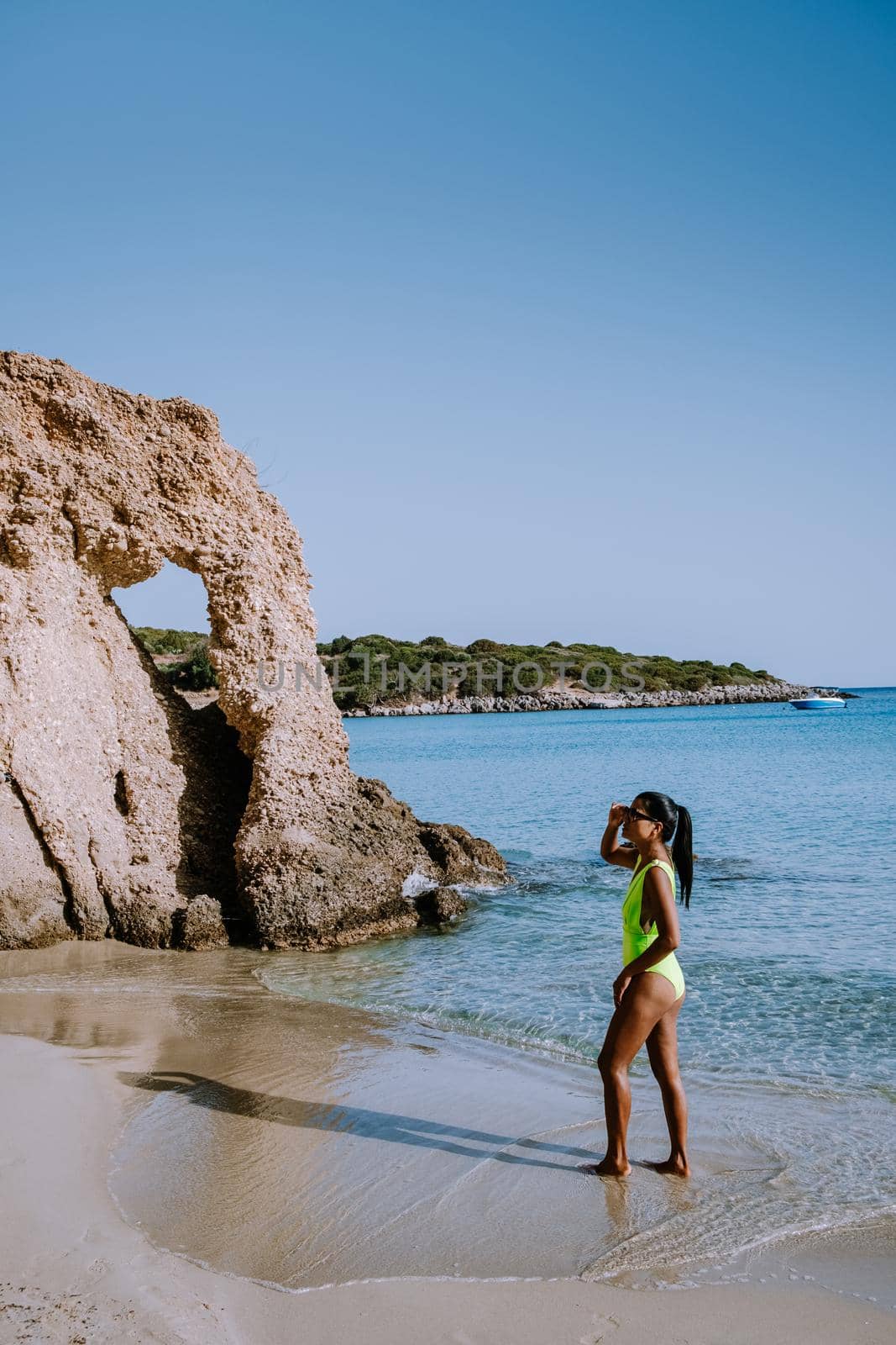 Tropical beach of Voulisma beach, Istron, Crete, Greece ,Most beautiful beaches of Crete island -Istron bay near Agios Nikolaos. young woman on the beach of Crete