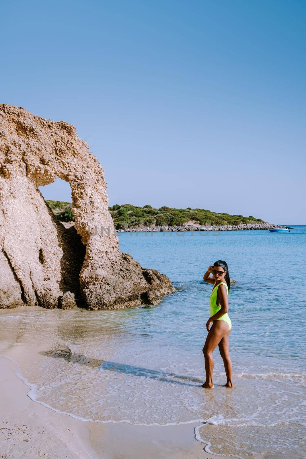 Tropical beach of Voulisma beach, Istron, Crete, Greece ,Most beautiful beaches of Crete island -Istron bay near Agios Nikolaos. young woman on the beach of Crete