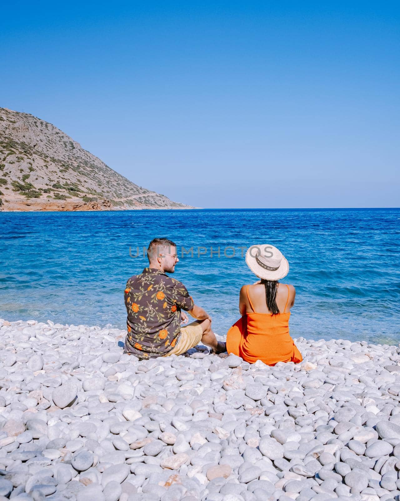 Plaka Lassithi with is traditional blue table and chairs and the beach in Crete Greece by fokkebok