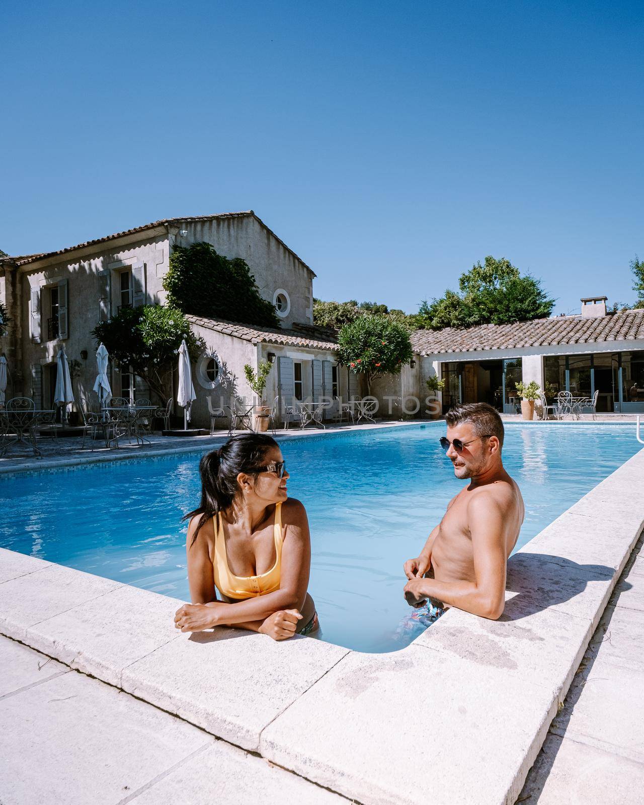 couple relaxing by the pool in the Provence France, men and woman relaxing by pool at luxury resort by fokkebok