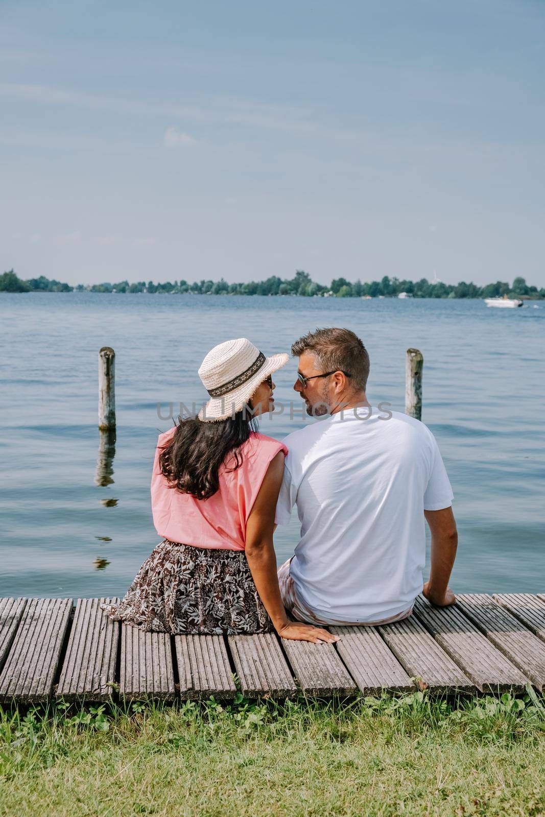 people relaxing in the park by the lake in the Netherlands Vinkeveen near Amsterdam, Vinkeveen is mainly famous for the Vinkeveense Plassen Lakes of Vinkeveen, an area of lakes and sand islands east of the village. It is an important recreational area Netherlands. Europe