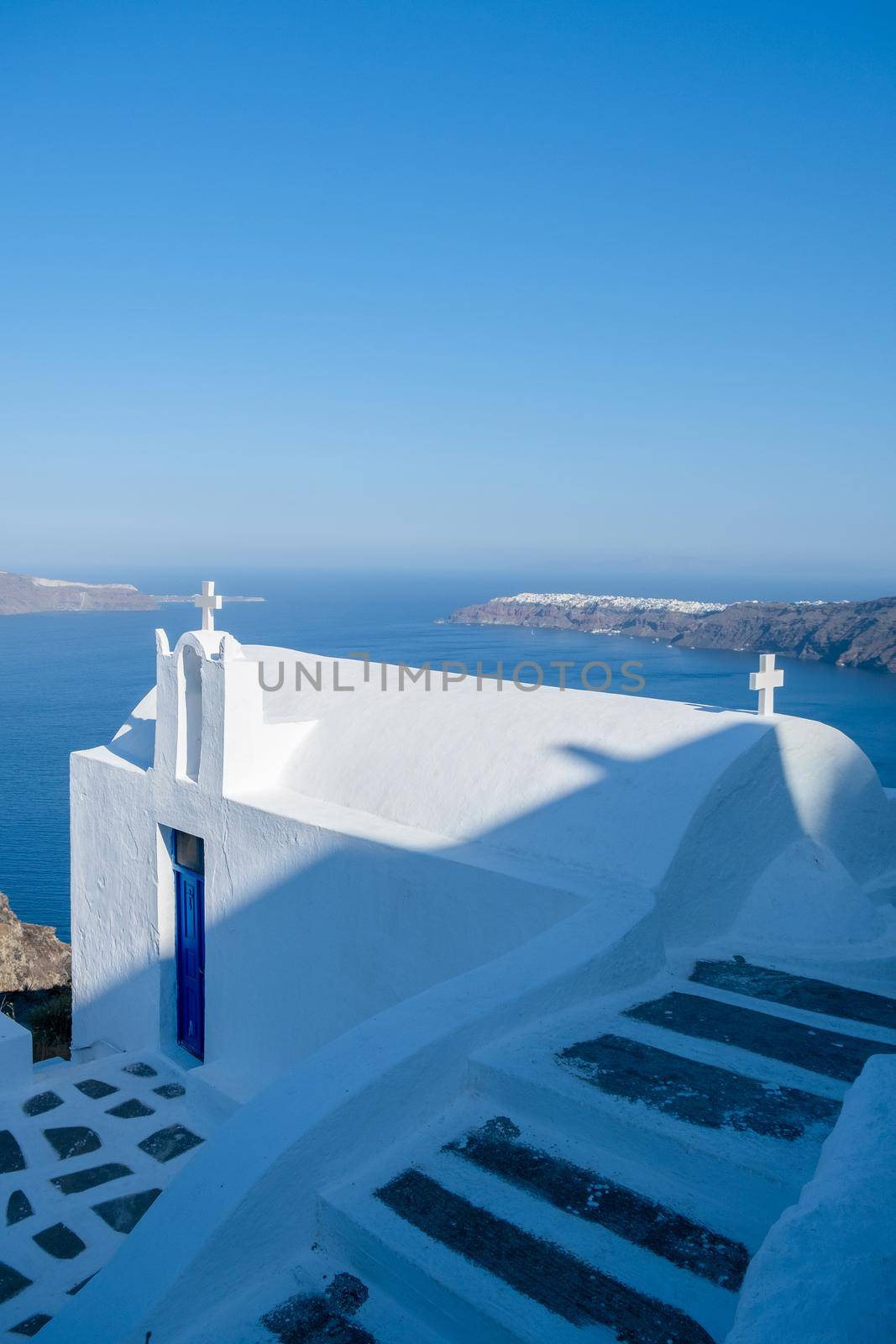White church at Fira Santorini, Panoramic view of mountains, sea and nature from Fira town, Santorini island Greece. View of the caldera and ships in the bay of Santorini