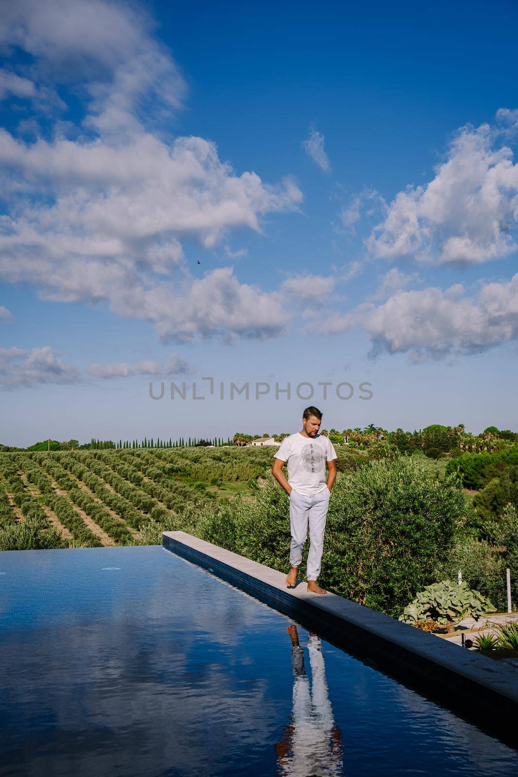 Luxury resort with a view over the wine field in Selinunte Sicily Italy. infinity pool with a view over wine fields in Sicilia men on vacation luxury hotel