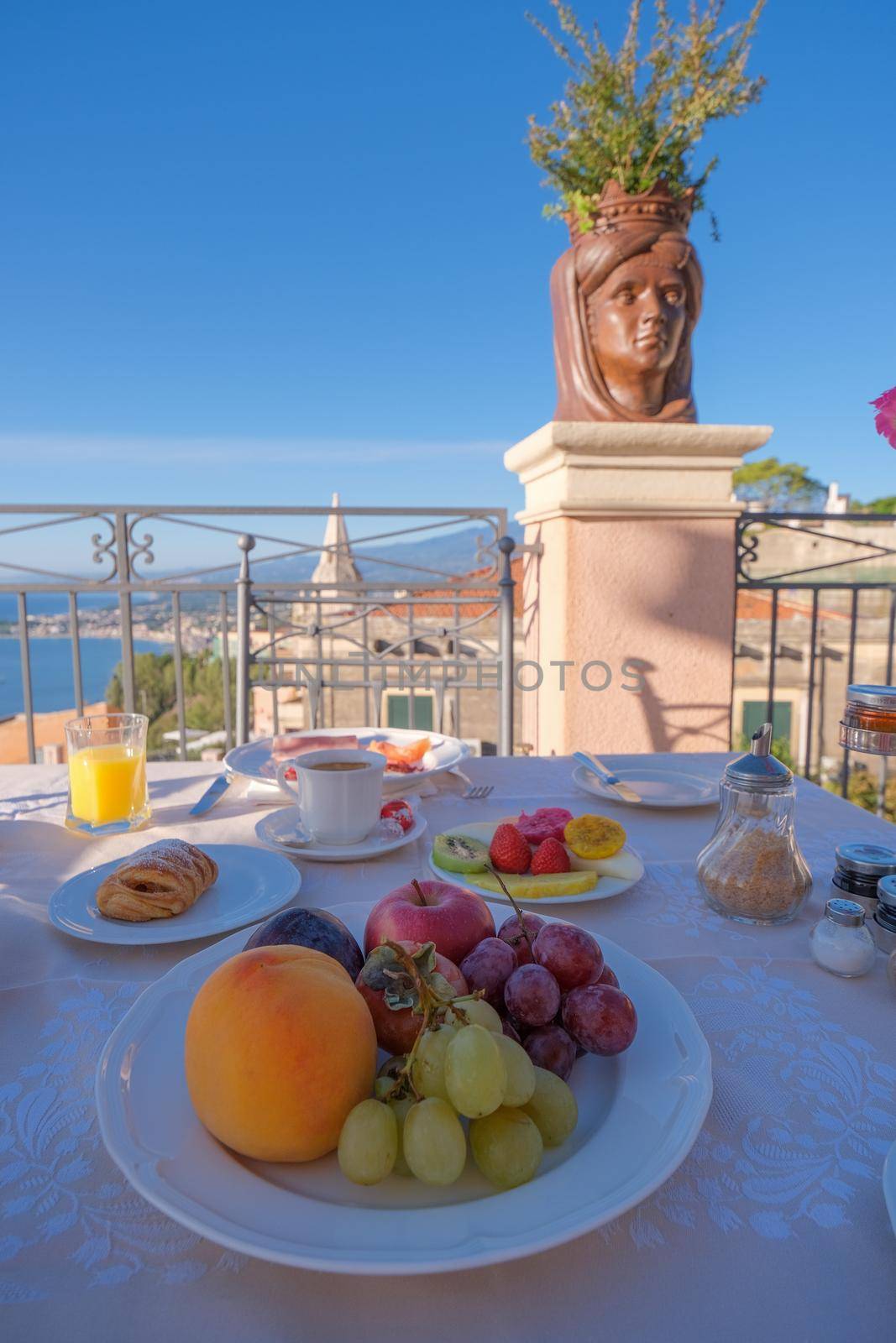 Taormina Sicily Italy breakfast table with a rooftop view over Taormina breakfast with coffee bread and fruit