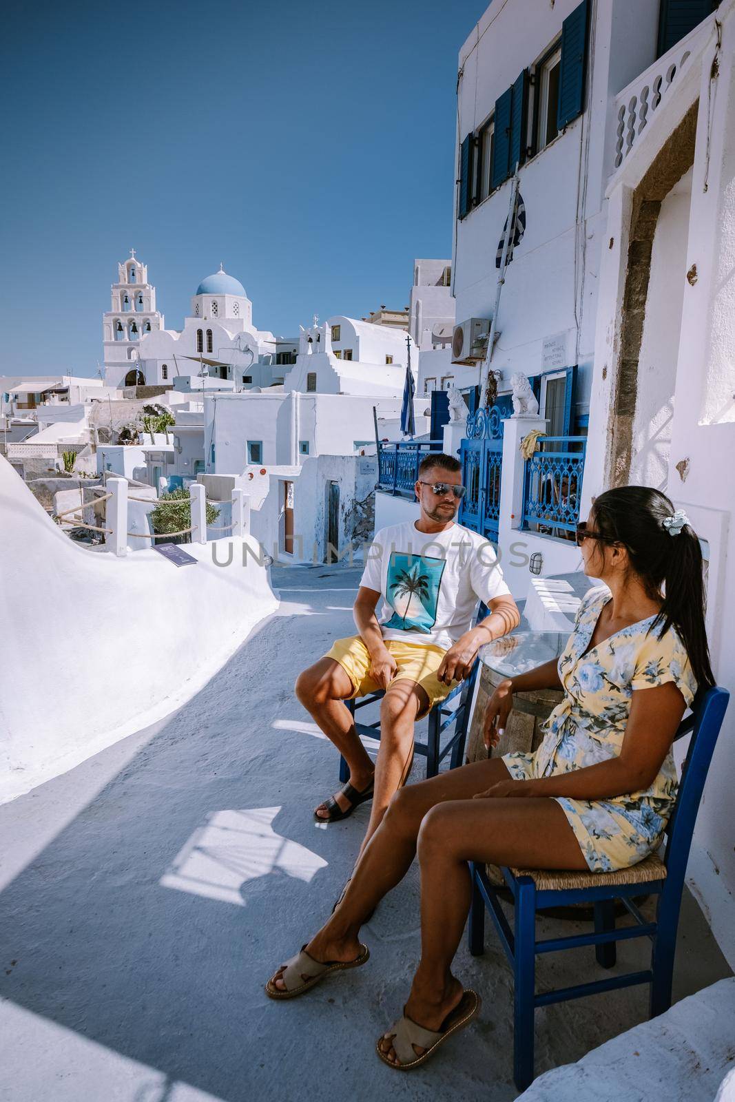 Pyrgos, Santorini, Greece. Famous attraction of white village with cobbled streets, Greek Cyclades Islands, Aegean Sea couple on vacation Santorini Greece by fokkebok