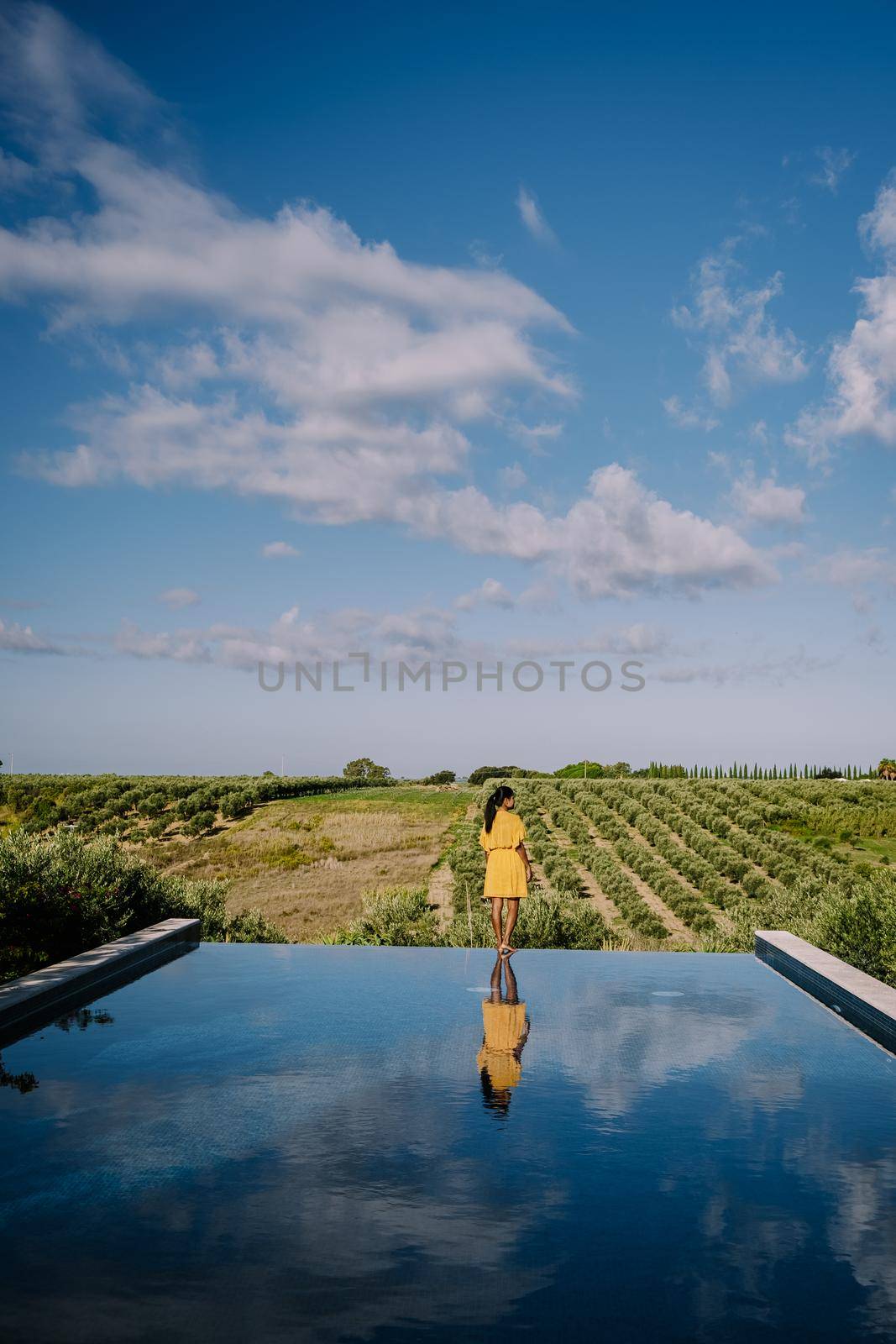 Luxury resort with a view over the wine field in Selinunte Sicily Italy. infinity pool with a view over wine fields in Sicilia, woman on vacation luxury resort