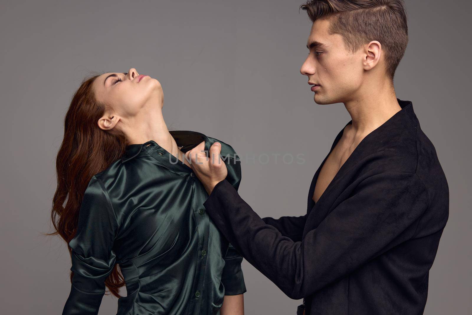 Strong man hurting woman on gray background domestic violence. High quality photo