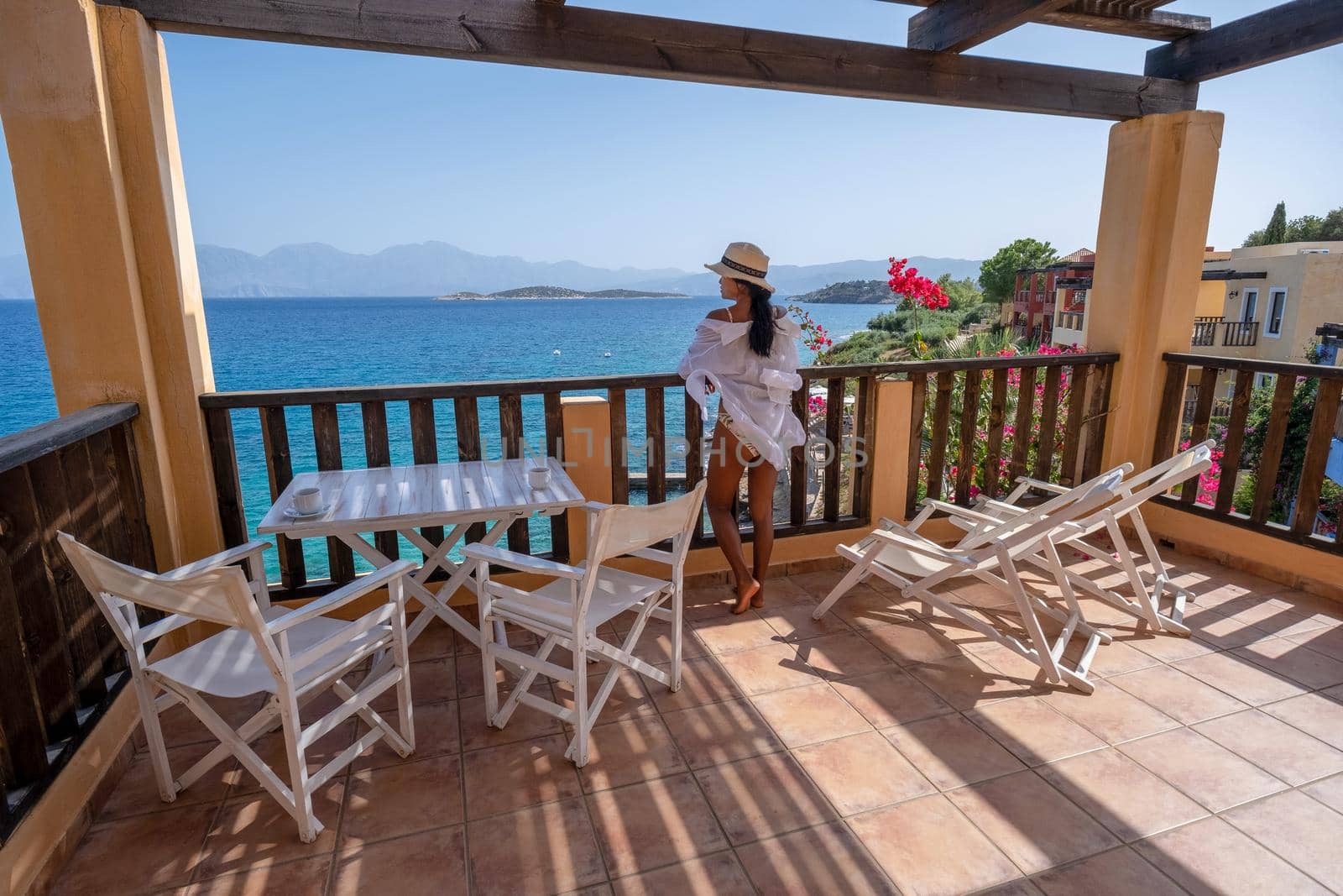 woman on balcony on holiday luxury vacation looking out over the ocean of Crete Greece by fokkebok