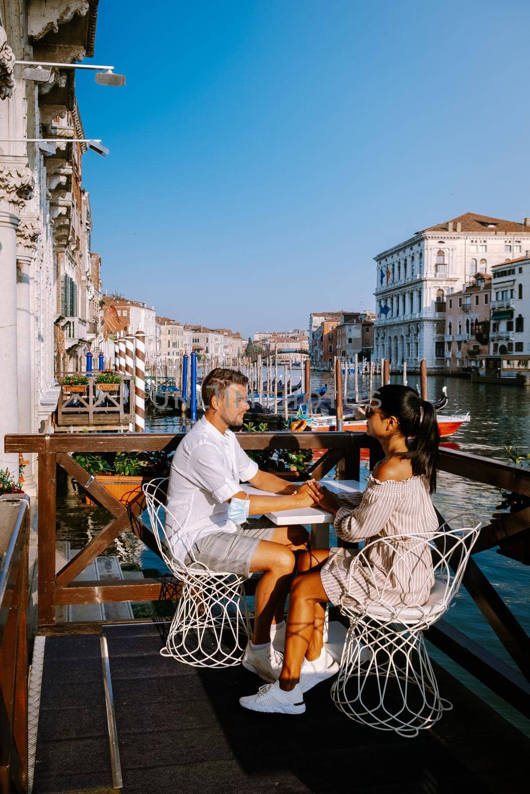 couple men and woman on a city trip to Venice Italy, colorful streets with canals Venice. Europe