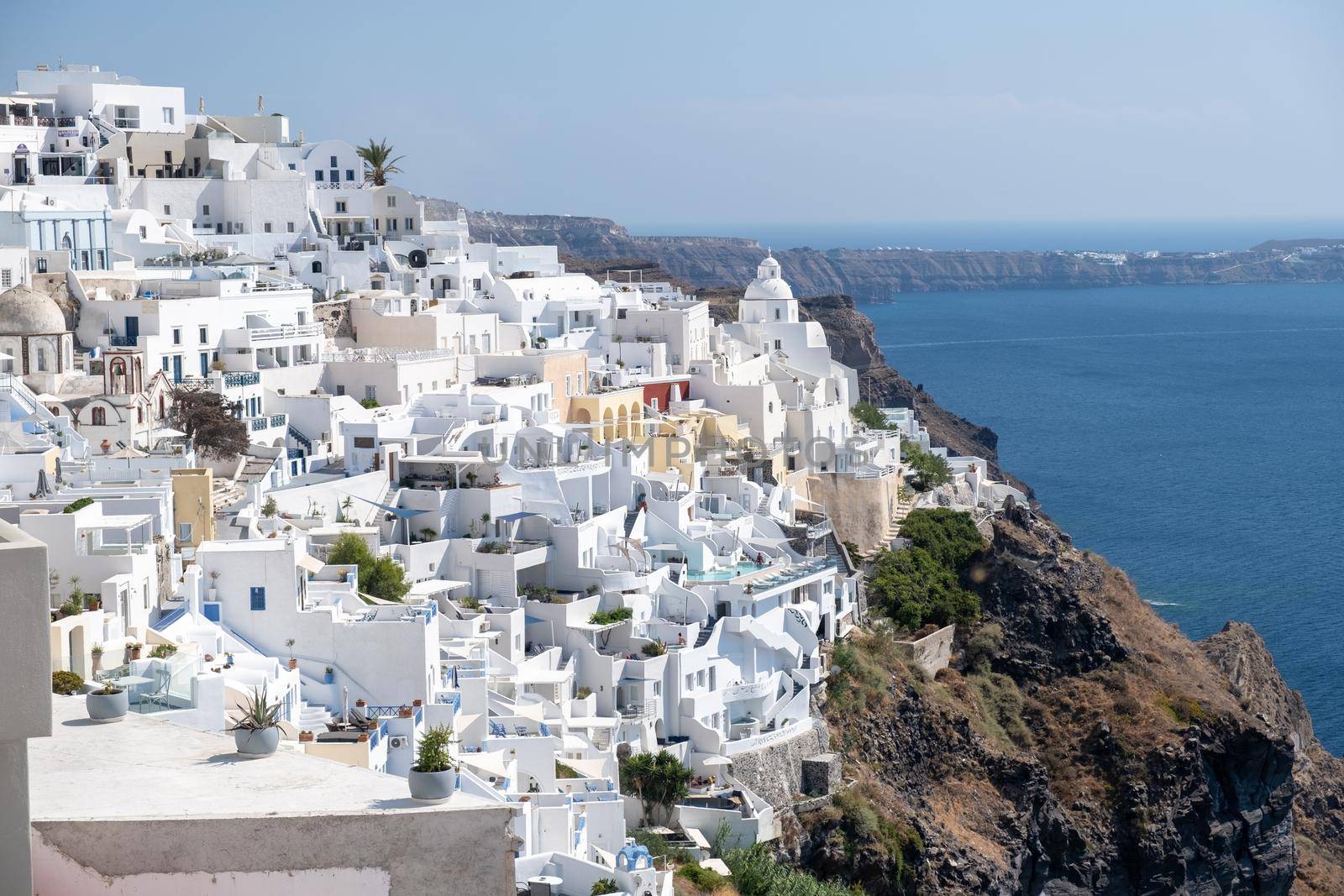 White church at Fira Santorini, Panoramic view of mountains, sea and nature from Fira town, Santorini island Greece. View of the caldera and ships in the bay of Santorini