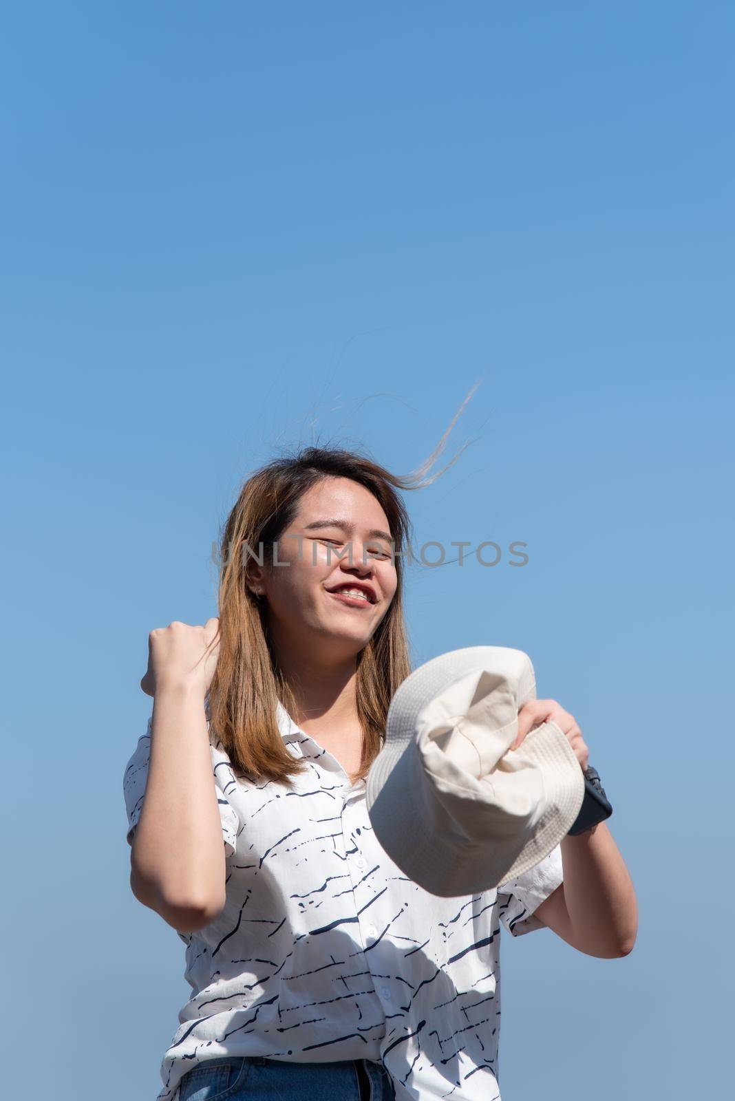 Asian pretty cute woman with hat relax at seaside city landscape viewpoint on mountain with happy and freedom emotion in concept travel, vacation, leisure in life