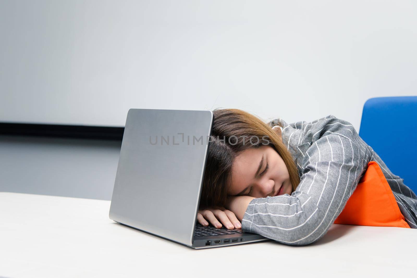Asian woman is student,businesswoman working by computer notebook, laptop in office meeting room with whiteboard background and nap or sleep for rest because of tired in concept working woman
