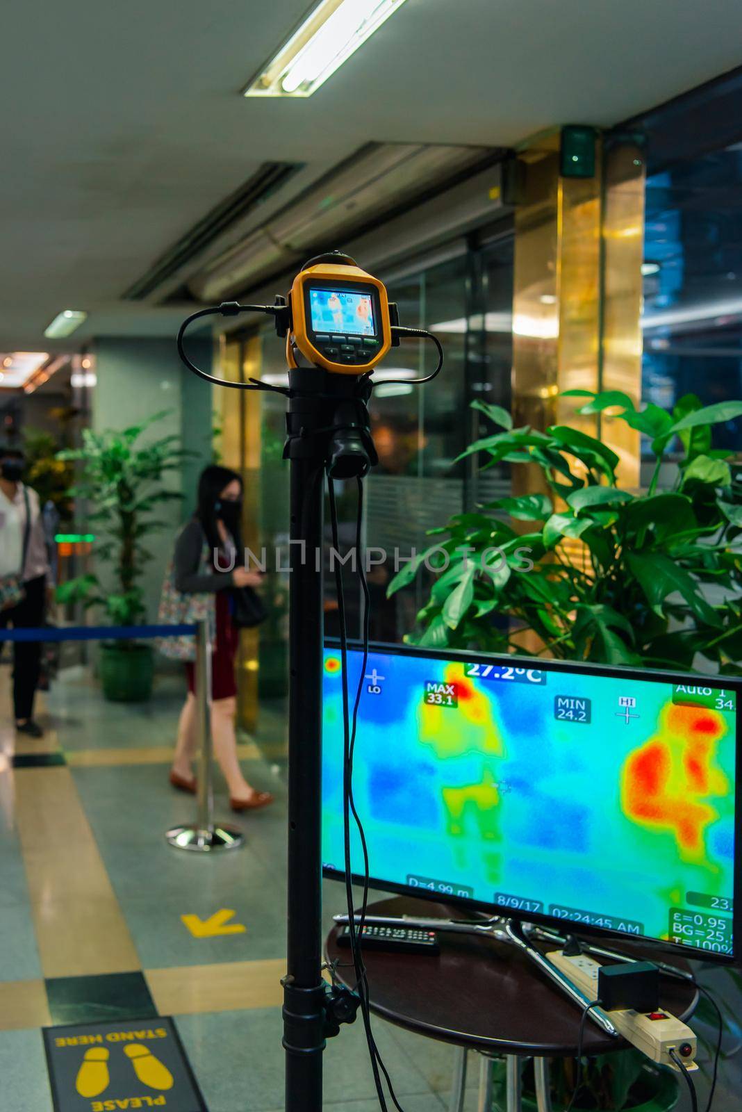 Asian people waiting for body temperature check before access to building for against epidemic flu covid19 or corona virus influenza in office by thermoscan or infrared thermal camera