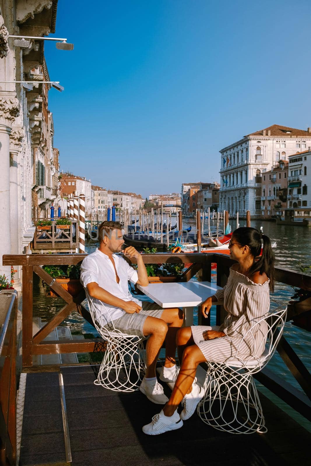 couple men and woman on a city trip to Venice Italy, colorful streets with canals Venice. Europe