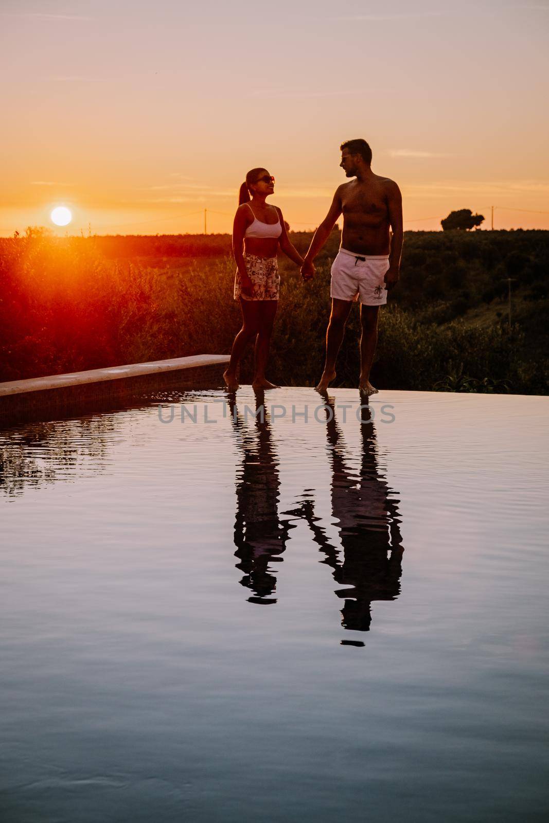 Luxury resort with a view over the wine field in Selinunte Sicily Italy. infinity pool with a view over wine fields in Sicilia, a couple on luxury vacation at the Island of Sicily Italy