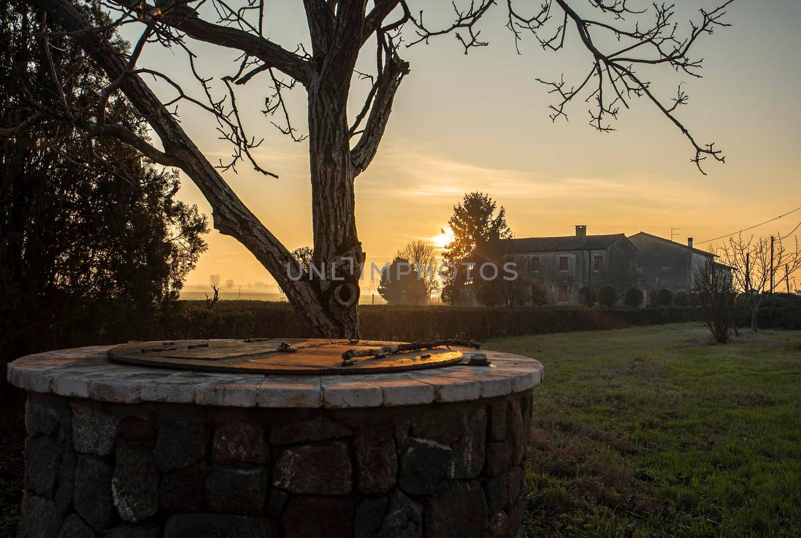 Water Well immersed in a countryside landscape at sunset time