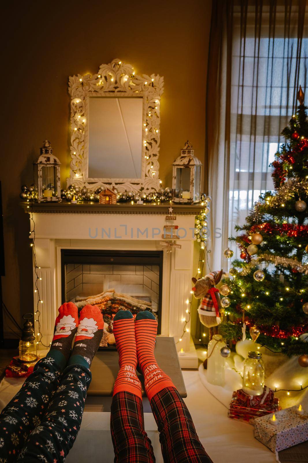 Christmas tree and fireplace, Christmas socks and hot chocolate cups by fireplace during Christmas holiday