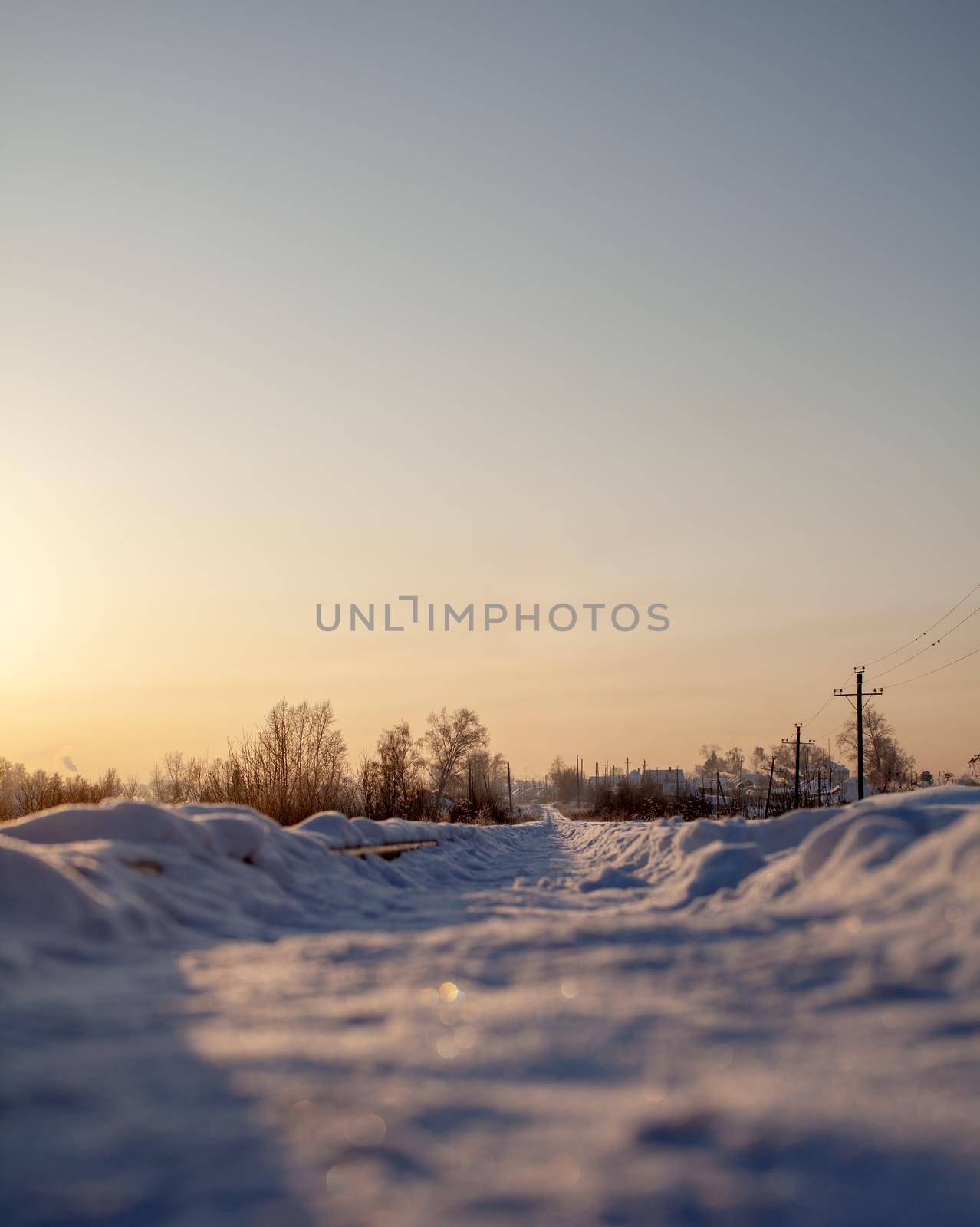 A snow-covered railway and a path trodden by people on it in winter. by AnatoliiFoto