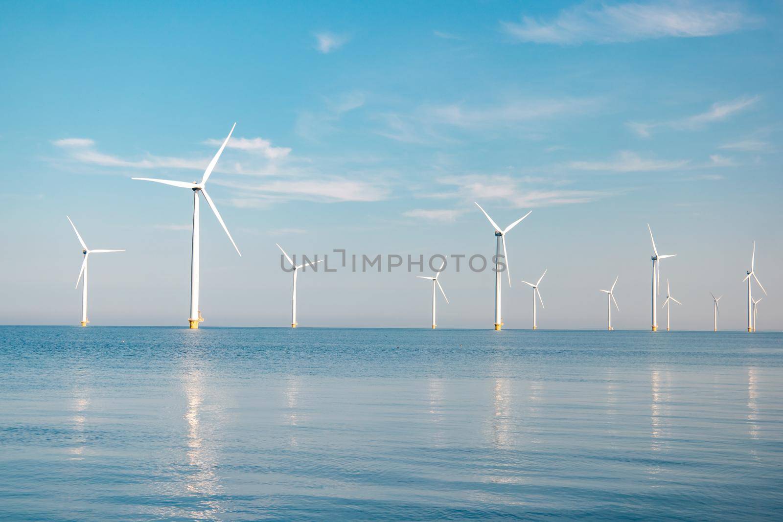 offshore windmill park with stormy clouds and a blue sky, windmill park in the ocean. Netherlands Europe